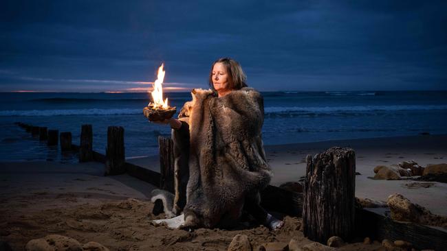 Wadawurrung Elder Aunty Mary Shuttleworth keeps the fire burning at Cosy Corner, Torquay at sunrise. Picture: Brad Fleet