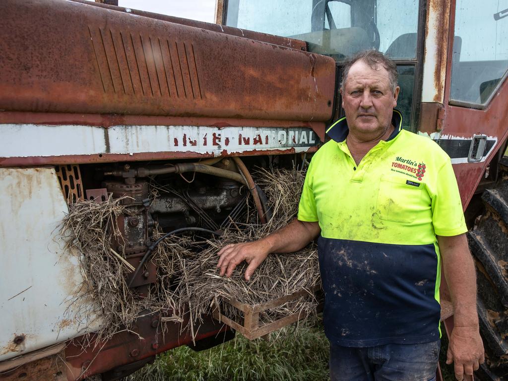 Jeff Martin is pictured with part of the floodwater debris choking his tractor. Picture: Jason Edwards