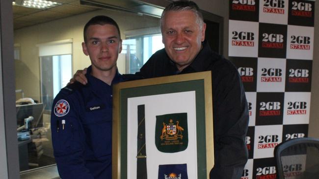 Ray Hadley presents paramedic Dalton Lynch with his grandfather’s Kangaroos tie.