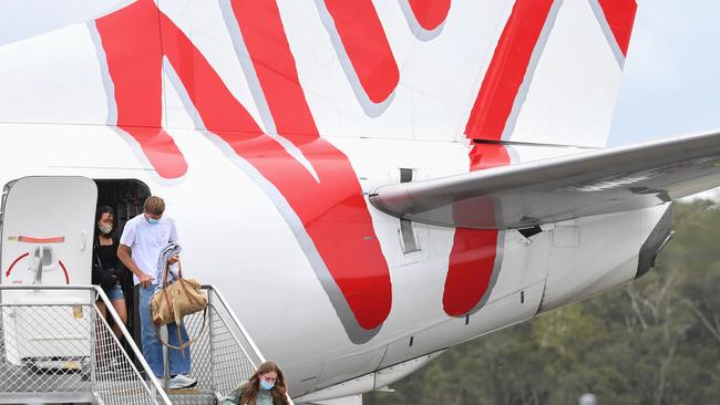 Passengers wearing face masks arrive on a Virgin Australia flight into Ballina Byron Gateway Airport.