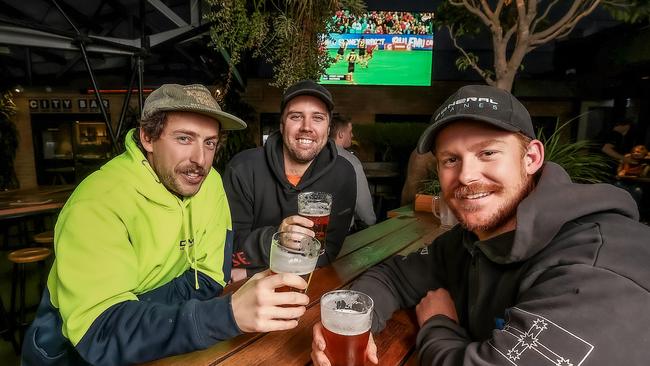 Mates Jordan Frederiksen, Greg Marshall and David Morford enjoy a beer at the Corner as pubs reopened after Melbourne’s lockdown last November. Picture: Ian Currie