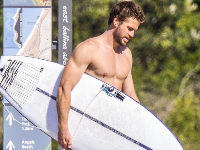 Surf time. Liam grabs his board; fans everywhere swoon. Picture: Media-Mode