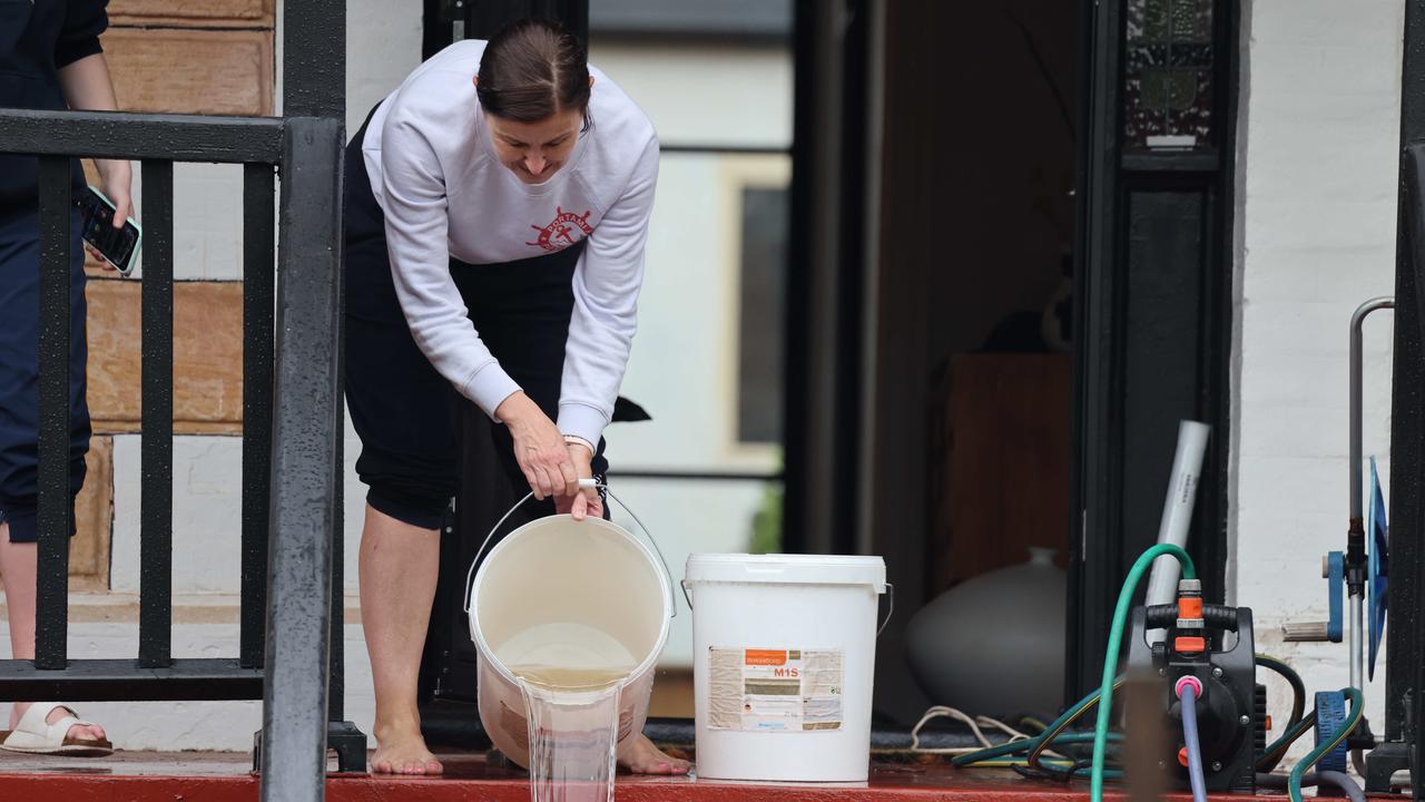 Colleen McDonnell emptying water from her home. Picture: Russell Millard Photography