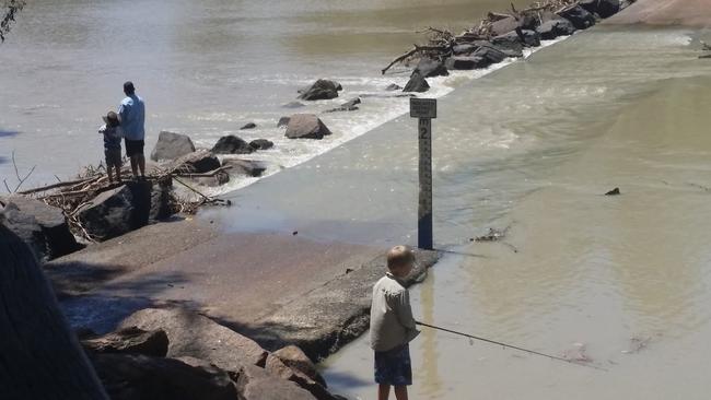 This family continued to fish with their young boys aged around seven and eight at the waters edge as more than 15 four metre crocs could be seen around the crossing. Some even went over the crossing into deeper water.