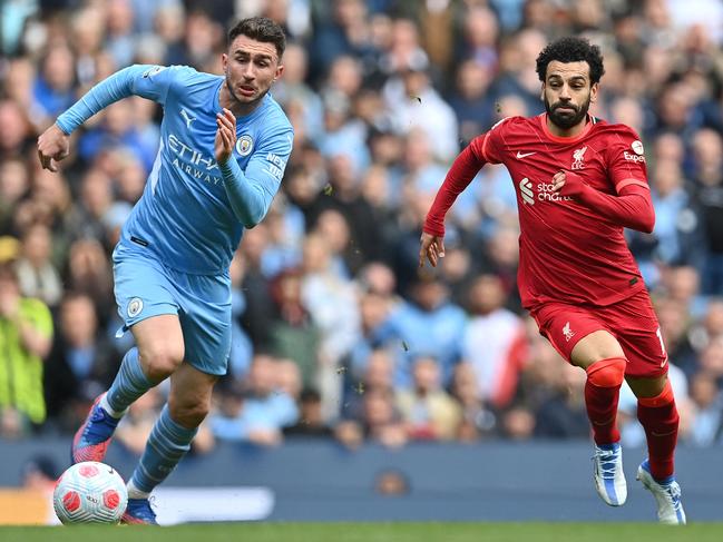 TOPSHOT - Liverpool's Egyptian midfielder Mohamed Salah (R) vies with Manchester City's French defender Aymeric Laporte during the English Premier League football match between Manchester City and Liverpool at the Etihad Stadium in Manchester, north west England, on April 10, 2022. (Photo by Paul ELLIS / AFP) / RESTRICTED TO EDITORIAL USE. No use with unauthorized audio, video, data, fixture lists, club/league logos or 'live' services. Online in-match use limited to 120 images. An additional 40 images may be used in extra time. No video emulation. Social media in-match use limited to 120 images. An additional 40 images may be used in extra time. No use in betting publications, games or single club/league/player publications. /