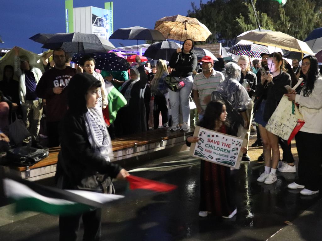 Protesters gathered at Surfers Paradise Esplanade despite torrential rain to call for an immediate ceasefire of bombing in the Gaza Strip. Picture: Amaani Siddeek