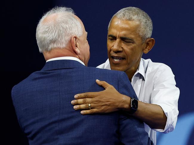 Former US President Barack Obama greets Minnesota Governor and Democratic vice presidential candidate Tim Walz during a campaign rally in support of Vice President and Democratic presidential candidate Kamala Harris, at Alliant Center in Madison, Wisconsin, on October 22, 2024. (Photo by KAMIL KRZACZYNSKI / AFP)