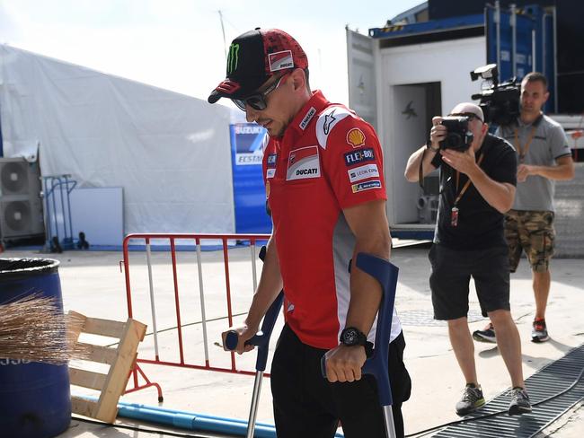 TOPSHOT - Ducati Team's Spanish rider Jorge Lorenzo walks around on crutches in the paddock area at Buriram International Circuit in Buriram on October 4, 2018. (Photo by Lillian SUWANRUMPHA / AFP)