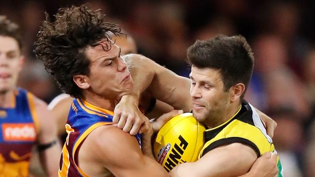 Trent Cotchin attempts to fend off a tackle from Brisbane Lions Cam Rayner. Picture: Michael Willson/AFL Photos via Getty Images.