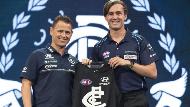 Lochie O'Brien receives a Carlton guernsey from coach Brendon Bolton on draft night. Picture: AAP