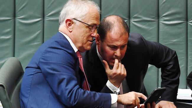 Malcolm Turnbull shares information on his phone with Josh Frydenberg at Parliament House in Canberra in 2017. Picture: AAP