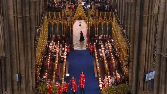 Royal watchers couldn’t believe their eyes when the dark cloaked figure wandered past the quire arch. Picture: BBC