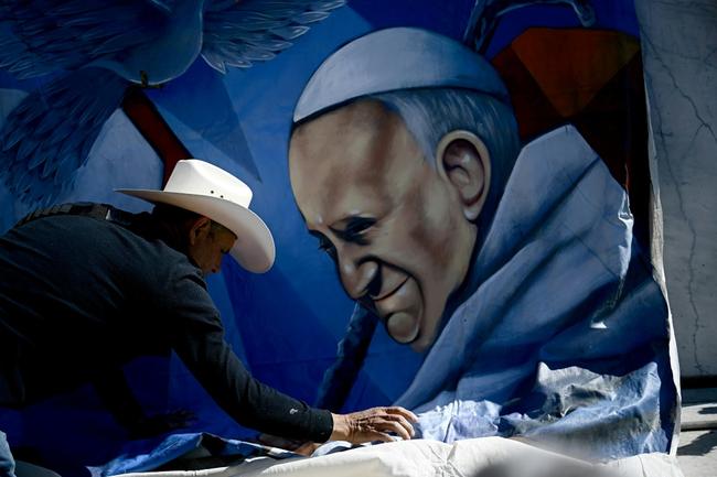 Mexican artist Roberto Marquez instals a portrait of Pope Francis outside the Rome hospital where the pontiff is hospitalised