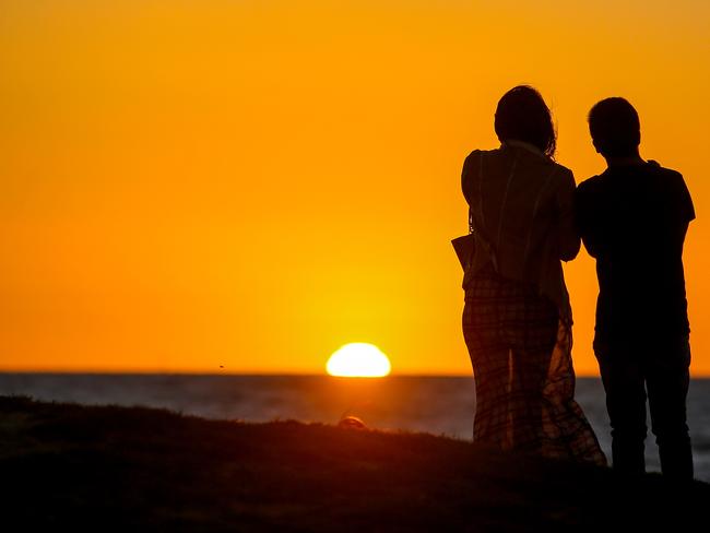 Melburnians watch the sunset on New Year’s Eve. Picture: Martin Keep