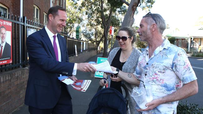 Labor candidate for Mayor Darcy Byrne hands out how to vote cards on polling day. Photo: Robert Pozo.