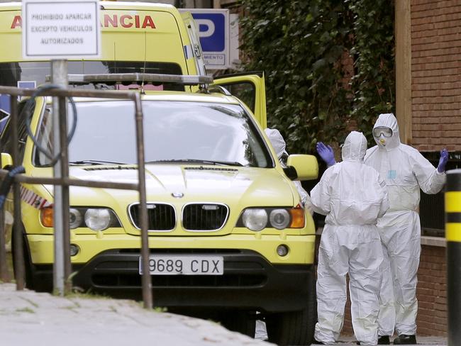 Medical workers wearing protective suit work close to the Gran hotel Colon that was transformed into a medical building to treat COVID-19 in Madrid, Spain. Picture: AP