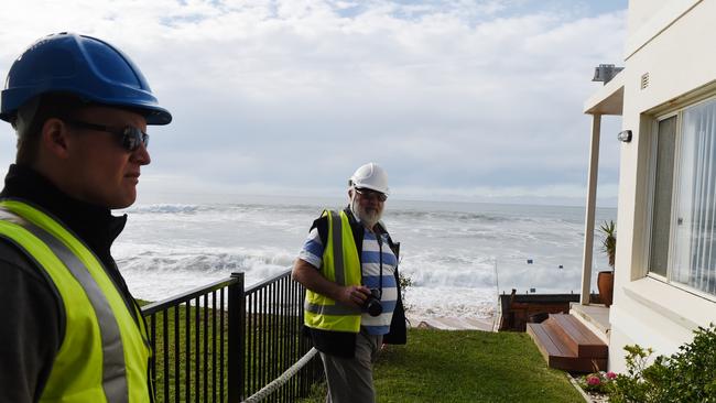 Warringah Council group manager of natural environments Todd Dickinson (left) and consultant coastal engineer specialist Angus Gordon (right) inspect damaged beachfront homes along Pittwater Road at Collaroy. Picture: AAP Image/Dean Lewins