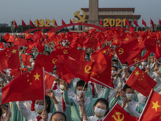 BEIJING, CHINA - JULY 01: Chinese students wave party and national flags at a ceremony marking the 100th anniversary of the Communist Party on July 1, 2021 at Tiananmen Square in Beijing, China. (Photo by Kevin Frayer/Getty Images)