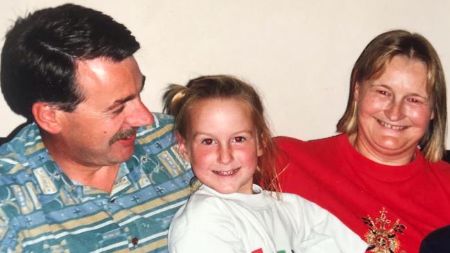 Coburg lawyer Cate Smith, 35, pictured as a child with her late parents Alison and Jeff Smith. Cate and her brother were conceived with Russell’s donated sperm through the Prince Henry Research Medical Centre. Pic Supplied.