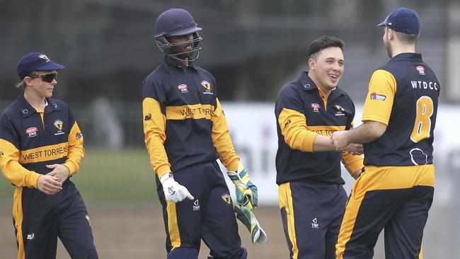 West Torrens’ Josh Dascombe, second right, celebrates taking the wicket of Woodville's Tom Andrews. Picture: AAP/Dean Martin