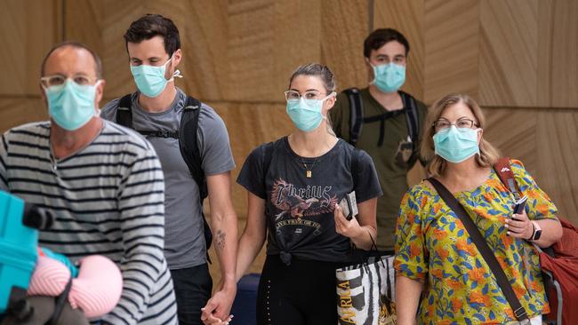 Travellers arriving from flight QF66 from Johannesberg wearing protective face masks at Sydney International Airport, Sydney, Friday, March 27, 2020. The Australia Federal Government have introduced strict social distancing rules in an effort to contain the COVID-19 Coronavirus pandemic.(AAP Image/James Gourley) NO ARCHIVING