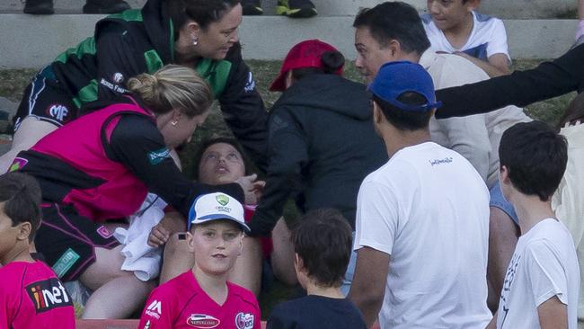 The spectator is treated after being hit by an Ellyse Perry six at North Sydney Oval on Saturday night.