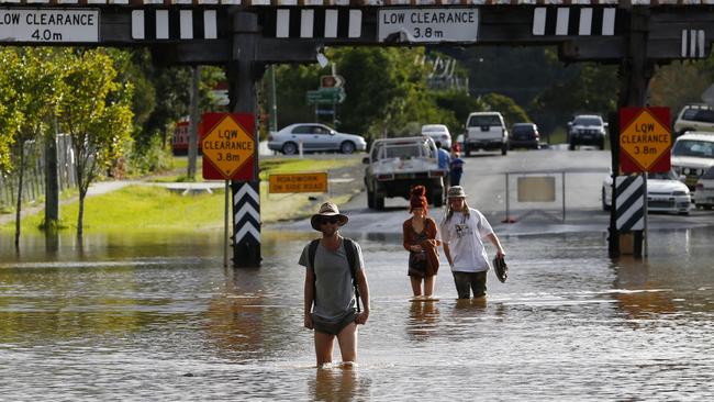 People walk through a flooded street in South Lismore / Picture: Jason O'Brien