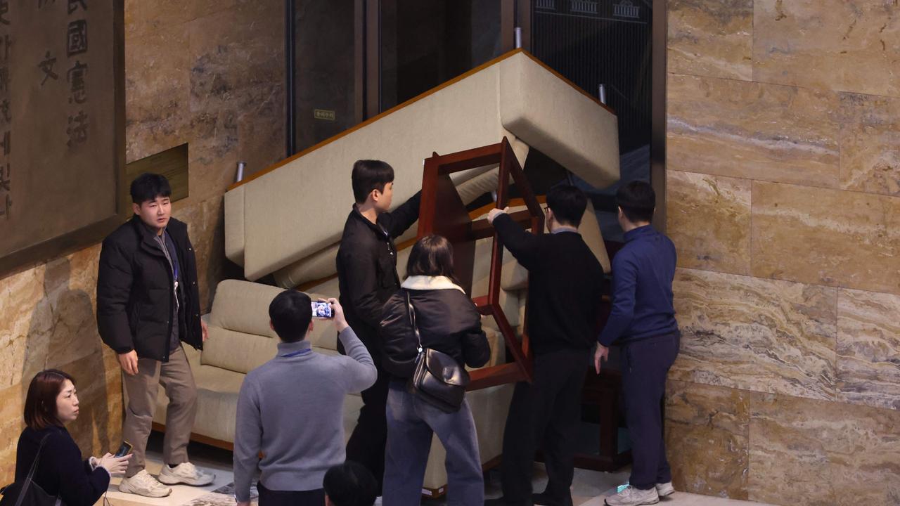 Members of South Korea's main opposition Democratic Party set up barricades at an entrance of the National Assembly building. Picture: YONHAP / AFP