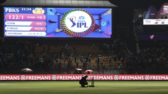 A worker removes the equipment placed next to the stumps after the authorities asked to evacuate the stadium in Dharamshala, India. Picture: AP Photo/Ashwini Bhatia