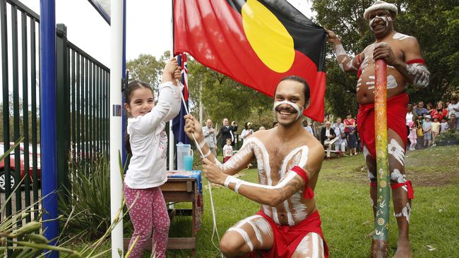 Elizabeth Badaoui helping Ray Kyle and Walangari Karntawarra (right) hoist the Aboriginal flag.