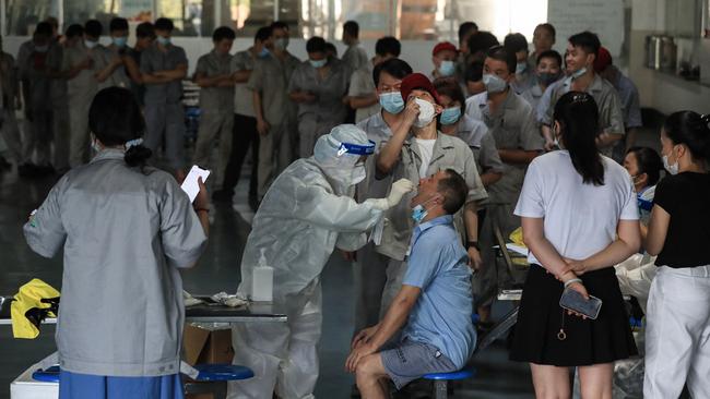 A worker receives a nucleic acid test for the Covid-19 coronavirus at the dining hall of a car parts factory in Wuhan this month. Picture: AFP