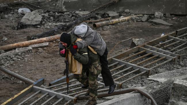 A man carries a woman on his back as people flee the city of Irpin, west of Kyiv, on March 7. Picture: AFP