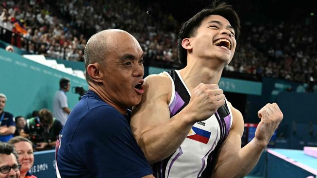 Yulo seen celebrating the win with his coach Aldrin Castaneda. Picture: Lionel Bonaventure / AFP