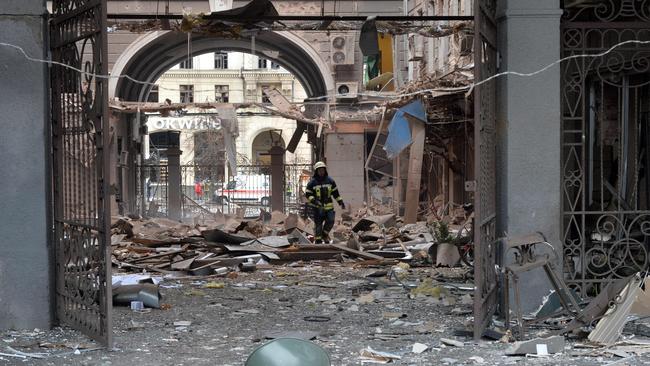 A firefighter walks among the rubble of a damaged building after shelling by Russian forces, at Constitution Square in Kharkiv. Picture: AFP