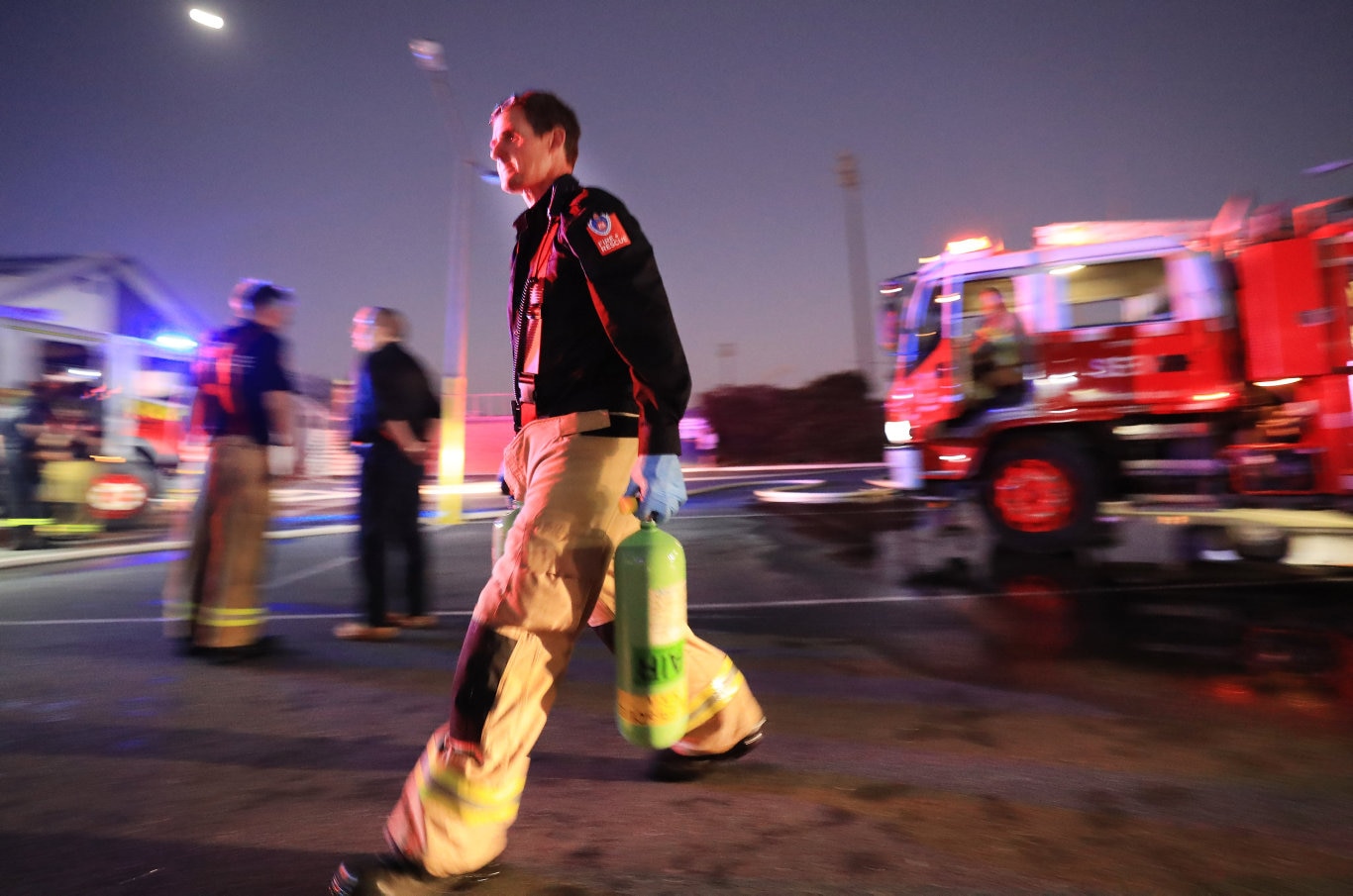 A Queensland Fire Brigade Officers rushes in spare breathing apparatus units to assist local Kingscliff and Tweed Units to fight the fire .Photo Scott Powick Newscorp