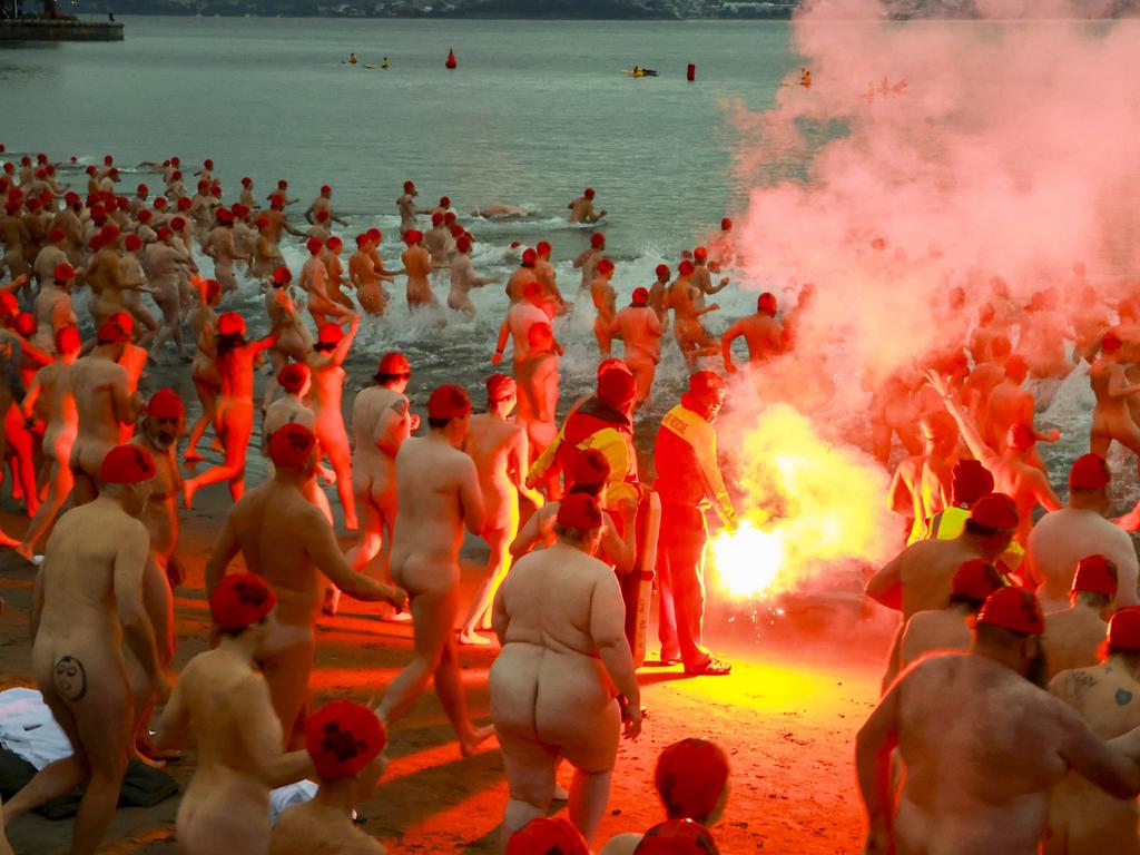 Brave swimmers gather round a fire before taking a dip in Tasmania’s Sandy Bay to welcome the winter solstice. Picture: NewsWire/Minch Media