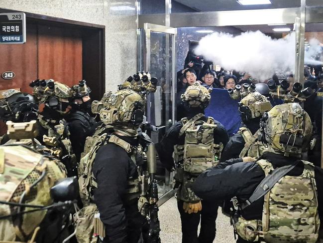 A National Assembly staff sprays fire extinguishers to block soldiers entering the main hall of the National Assembly in Seoul, South Korea, Wednesday, Dec. 4, 2024. (Jo Da-un/Yonhap via AP)