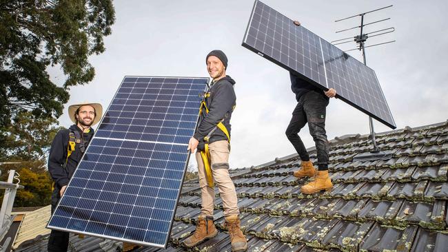 Darcy Hammet, Antonio Wiesner and James Williams install solar panels on a suburban Melbourne roof. Picture: Mark Stewart