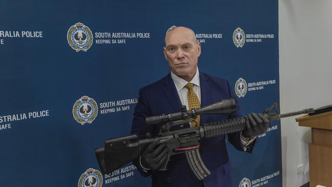 Detective Superintendent Steve Taylor, officer-in-charge of the Serious and Organised Crime Investigation Branch, with a high-powered military rifle linked to the Comanchero bikie gang seized in 2020 Picture: Roy Van Der Vegt