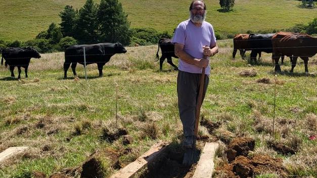 Victor Rullis breaks ground on his wife Miriam's grave.