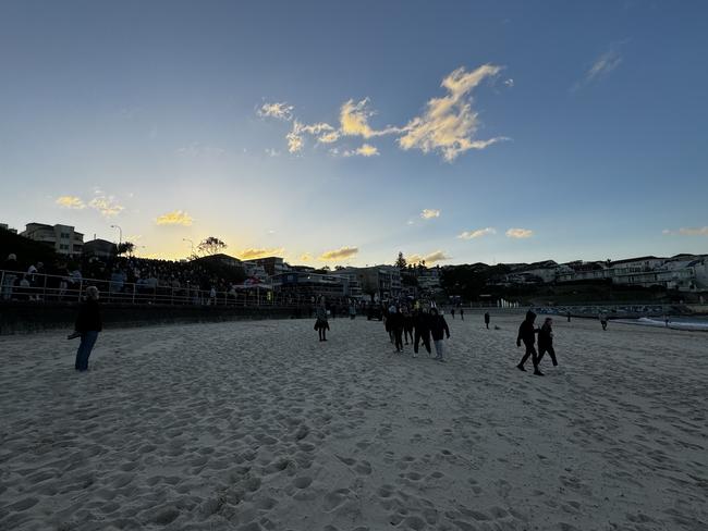 Many pause for a moment of reflection on the beach.