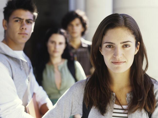 Please credit Thinkstock Young men and women standing holding folders, portrait