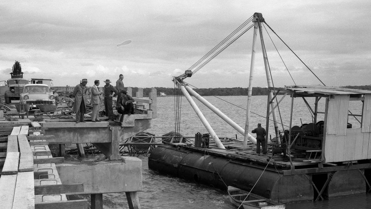 8/8/1963. Investigators start probing the cause of an industrial accident during construction of the Bribie Island bridge, north of Brisbane. A crane’s mechanism failed as a bearer was being lifted into place on the Bribie end of the bridge, allowing the 22m pre-stressed concrete bearer to crash into the water. Picture by Ray Saunders.