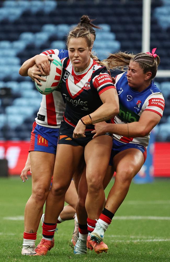 Isabelle Kelly carries two Knights defenders. Picture: Jeremy Ng/Getty Images