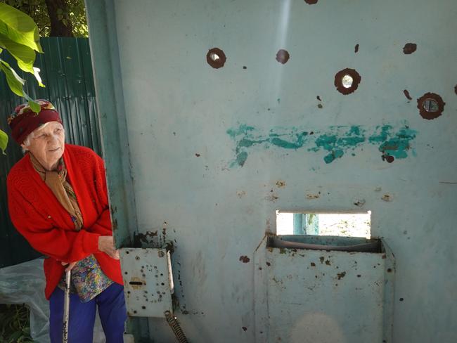 An elderly resident looks out of the front gate of her home on Saturday after it was riddled with holes from a cluster bomb attack the day before. Picture: Scott Olson/Getty