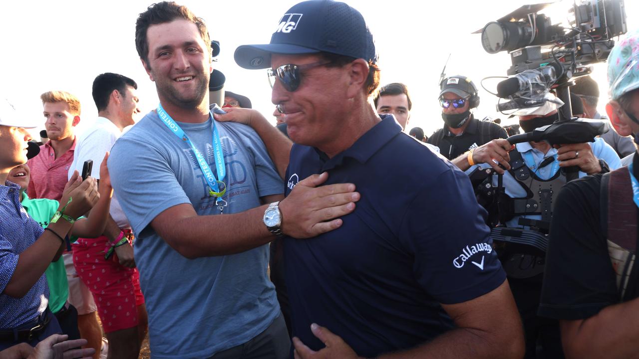 Phil Mickelson is congratulated by Jon Rahm on the 18th green.