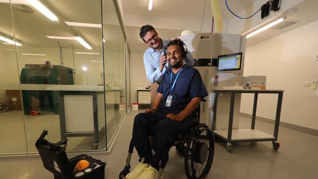 BioSpine research team team lead Dr Dinesh Palipana, himself a quadraplegic, with co lead Dr Claudio Pizzolato, trying on the headset to assist in thought control of the rehab process. Picture Glenn Hampson.