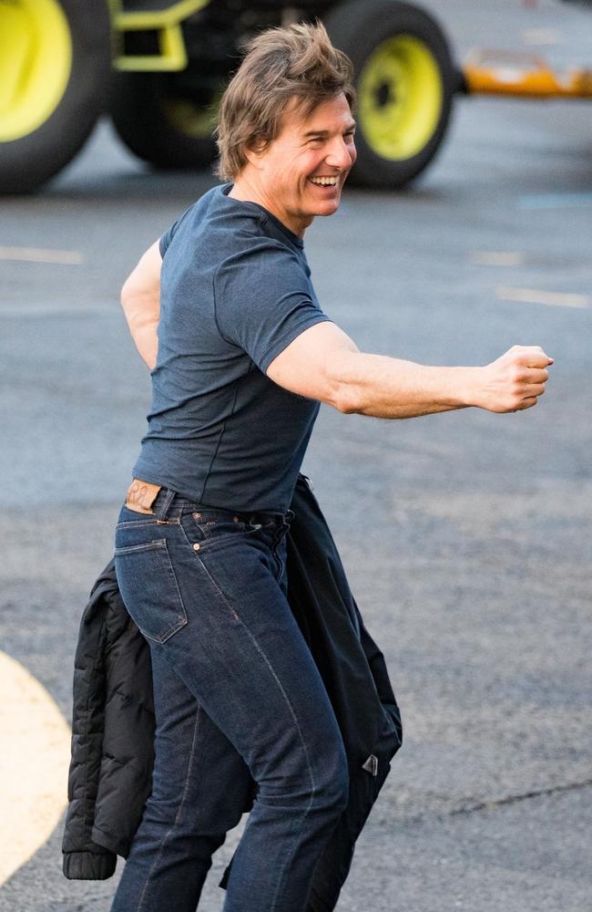 Tom Cruise holds out his hand for a fist bump as he leaves his helipad in London. Picture: Backgrid