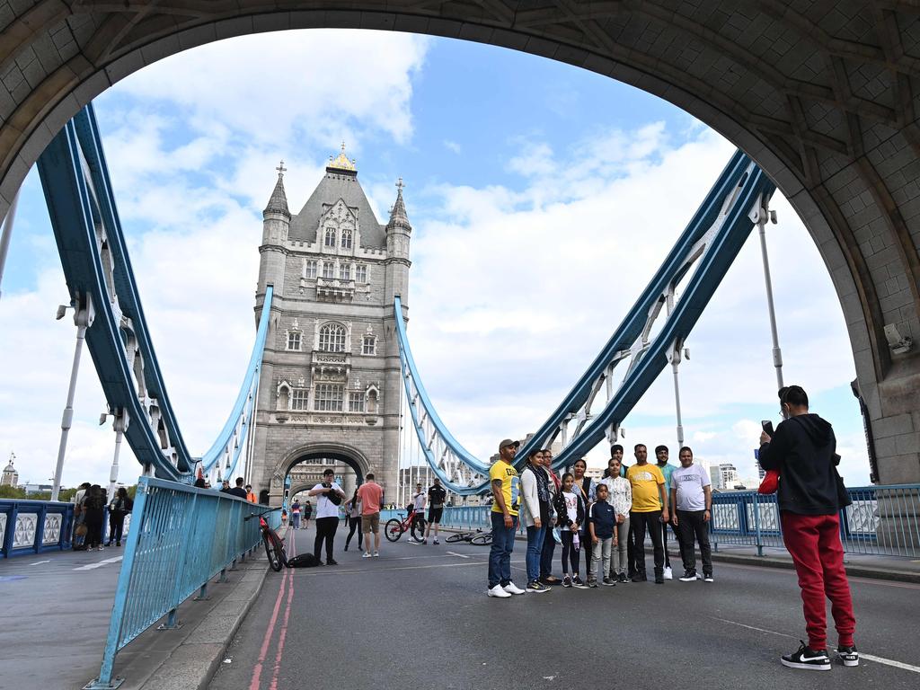 People pose for photographs in the empty road on Tower Bridge in central London after it stayed closed to traffic due to a technical fault the day before. Picture: Justin Tallis/AFP