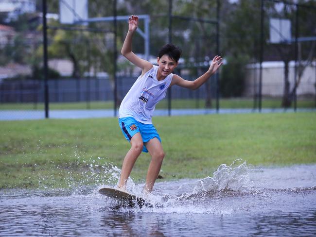 Elanora schoolboy Style Hogan gets some skim boarding practice in after heavy rain Photo: Scott Powick.